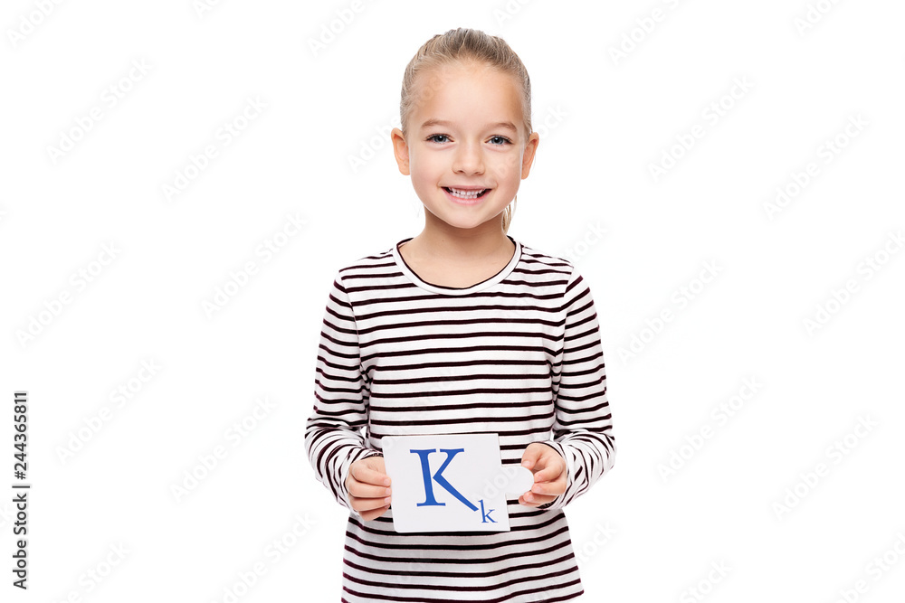 Young girl holding a card with letter K. Speech therapy concept on white background. Correct pronounciation and articulation at preschool age. Young girl holding a card with letter K. Speech therapy concept on white background. Correct pronounciation and articulation at preschool age.