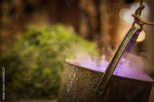 Cauldron with purple magic boiling potion or witching toxic poison soup. Object for Halloween, horror or fantastic themes