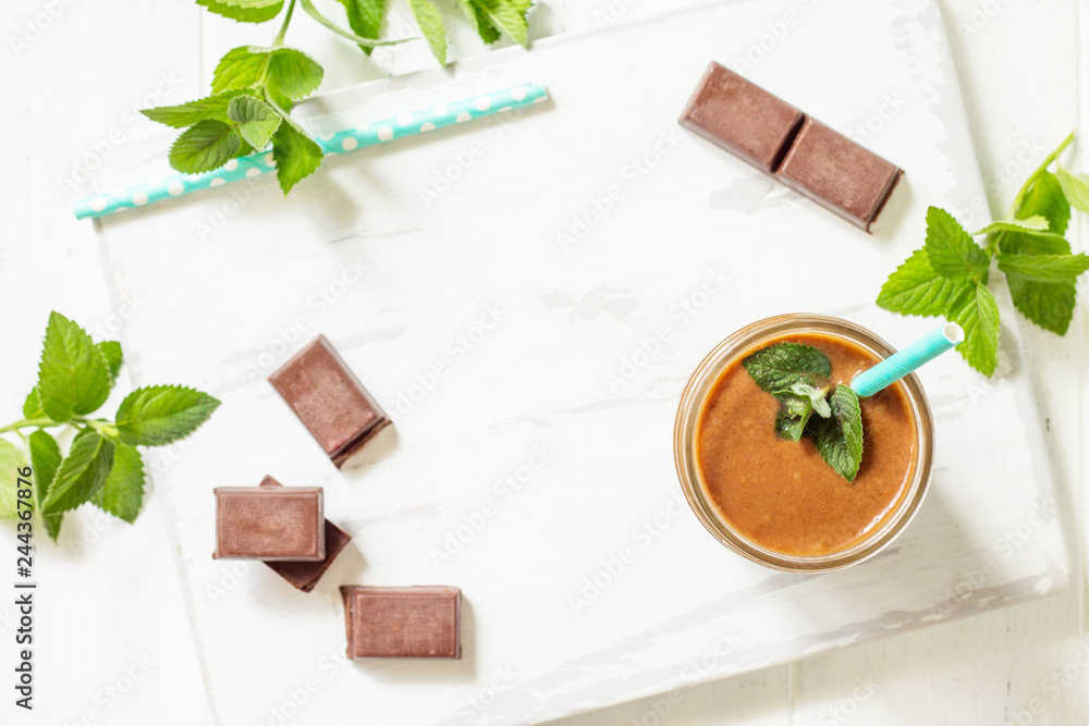 Chocolate milkshake or smoothies on a white wooden background. Healthy juicy vitamin drink diet or vegan food concept. Top view flat lay background. Copy space. Chocolate milkshake or smoothies on a white wooden background. Healthy juicy vitamin drink diet or vegan food concept. Top view flat lay background. Copy space.