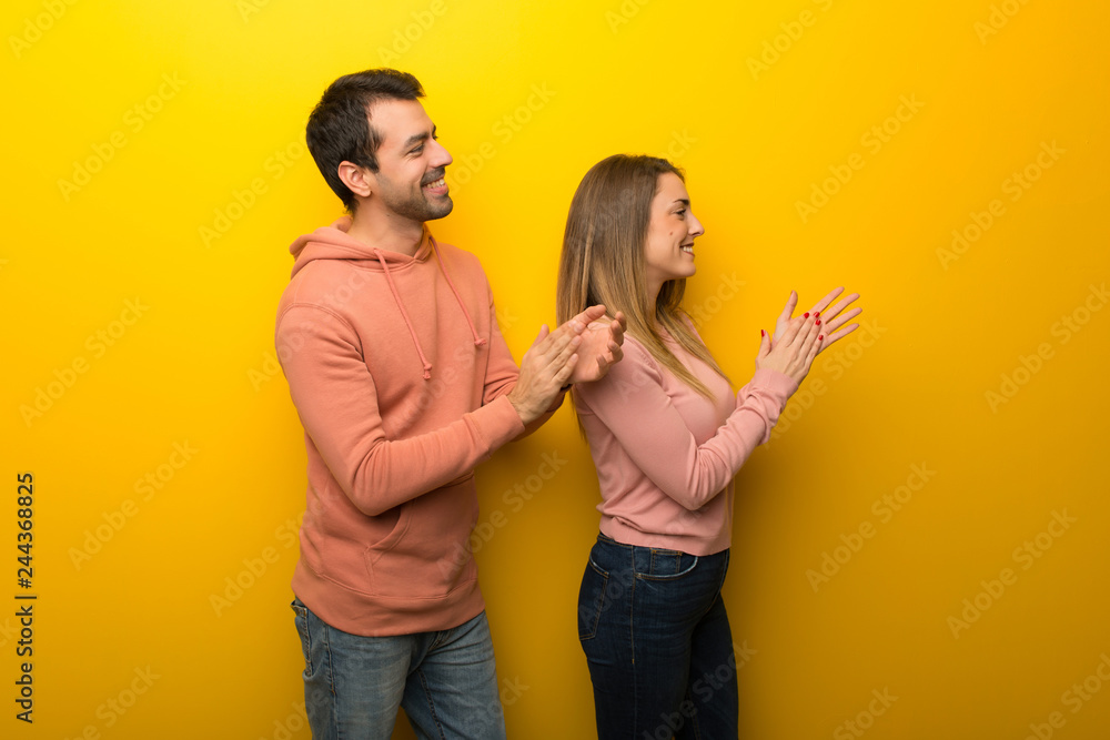 Obraz premium Group of two people on yellow background applauding after presentation in a conference
