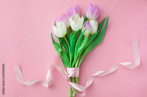Fototapeta Naklejka Na Ścianę i Meble -  Bouquet of tulips on a pink pastel background. Wonderful spring breakfast on Mother's Day or Women. Flat lay. View top. Selective focus.