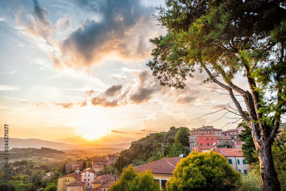 Chiusi sunset evening in Umbria, Italy with rooftop houses on mountain countryside rolling hills and colorful picturesque cityscape sun