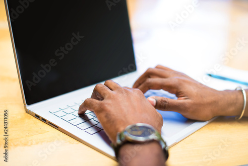 Detail of afro american businessman in the office with his laptop