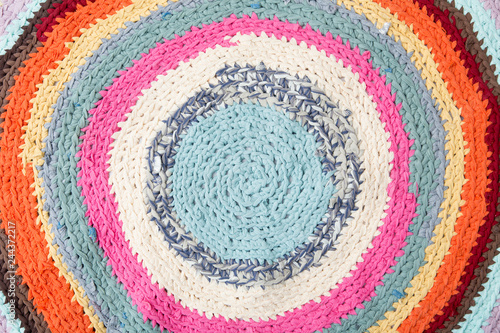 Colorful crochet rug from repurposed T-shirts at home floor. Flat lay view.