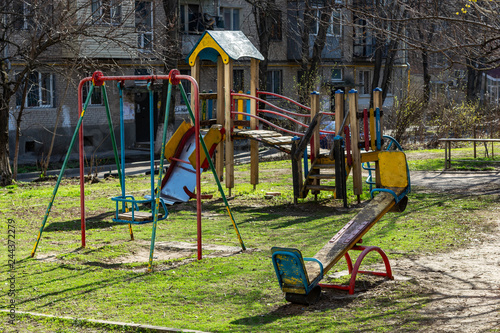 an old playground stands in the courtyard of a residential building
