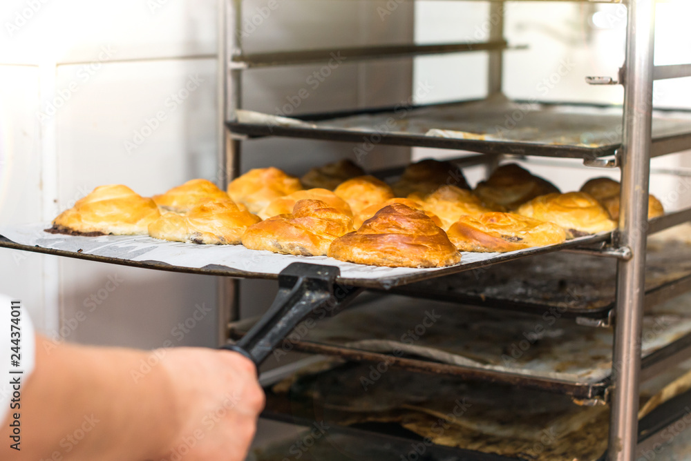 Woman in the kitchen of a bakery cooking cakes