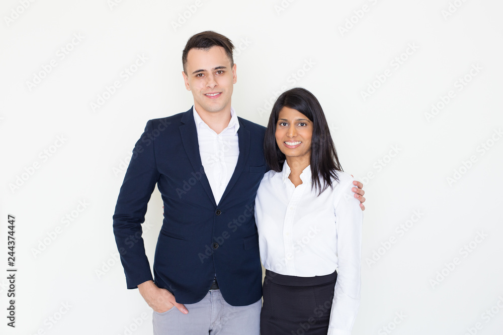 Happy couple of employees wearing office clothes. Positive young Caucasian man in trendy jacket hugging his Indian girlfriend in white blouse. Colleagues dating concept Happy couple of employees wearing office clothes. Positive young Caucasian man in trendy jacket hugging his Indian girlfriend in white blouse. Colleagues dating concept