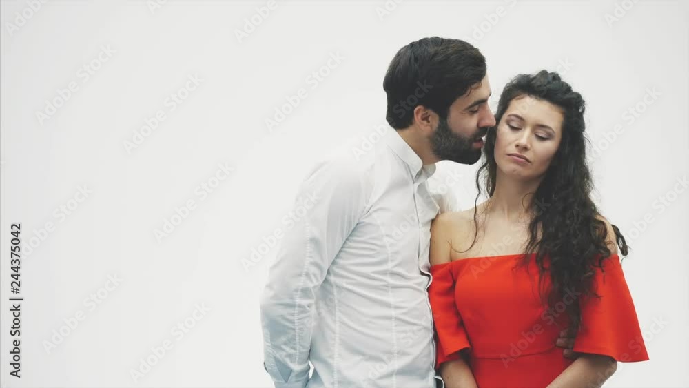Beautiful young couple. Incredibly in love Hug kissing and enjoying time together. Valentine's Day Celebration. The guy gives the gift box to the girl in a red dress. Beautiful young couple. Incredibly in love Hug kissing and enjoying time together. Valentine's Day Celebration. The guy gives the gift box to the girl in a red dress.