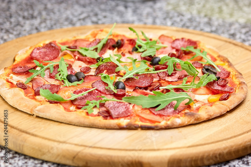 Fresly baked salami italian pizza. Homemade italian pizza with salami and olives. Pizza Quattro Carne.