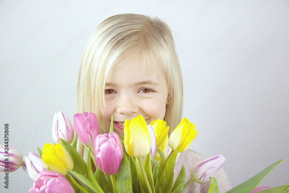 Kind mit einem Blumenstrauß.Bunte Tulpen Kind mit einem Blumenstrauß.Bunte Tulpen