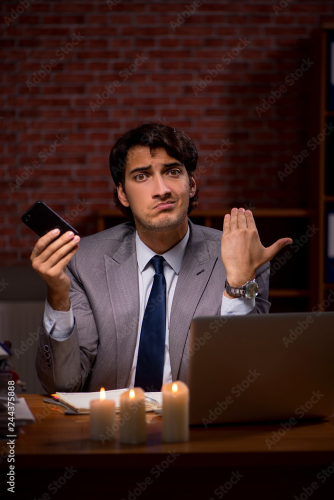Businessman working late in office with candle light Businessman working late in office with candle light