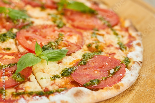 Close up tomato pizza crust. Macro focus tomato pizza crust with greens.