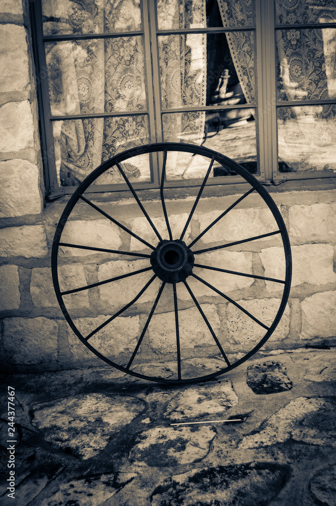 Two tone photo of an old wagon wheel.