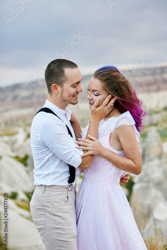 Embrace and kiss a couple in love on a spring morning in nature. Valentine's day, a close relationship between a man and a woman. Man kissing girl with bright colored hair, creative coloring