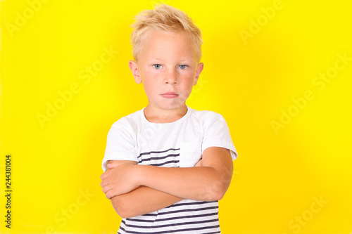 Cute blond boy portrait on yellow background