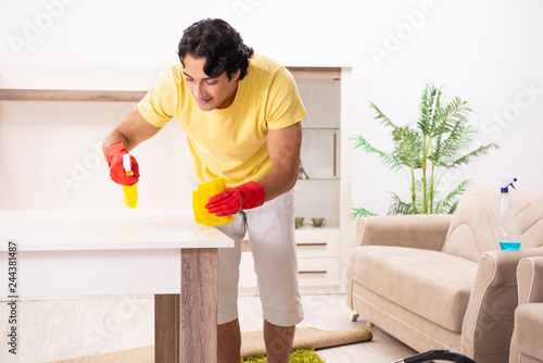 Young handsome man doing housework 