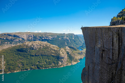 фотографія Hiker standing on Preikestolen and looking on the fjerd, Preikestolen - famous c
