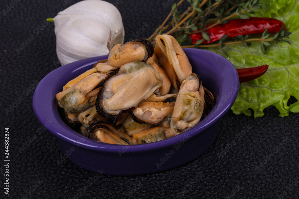 Pickled mussels in the bowl served pepper, garlic and salad Pickled mussels in the bowl served pepper, garlic and salad
