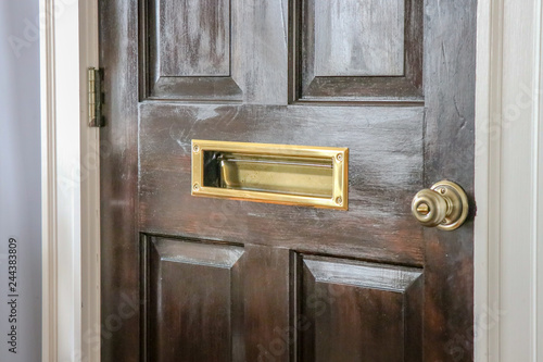 wooden front door with mail slot, door is locked