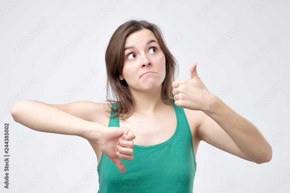 beautiful young woman showing thumbs down and up sign beautiful young woman showing thumbs down and up sign