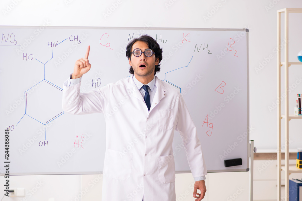 Young funny chemist in front of white board Young funny chemist in front of white board