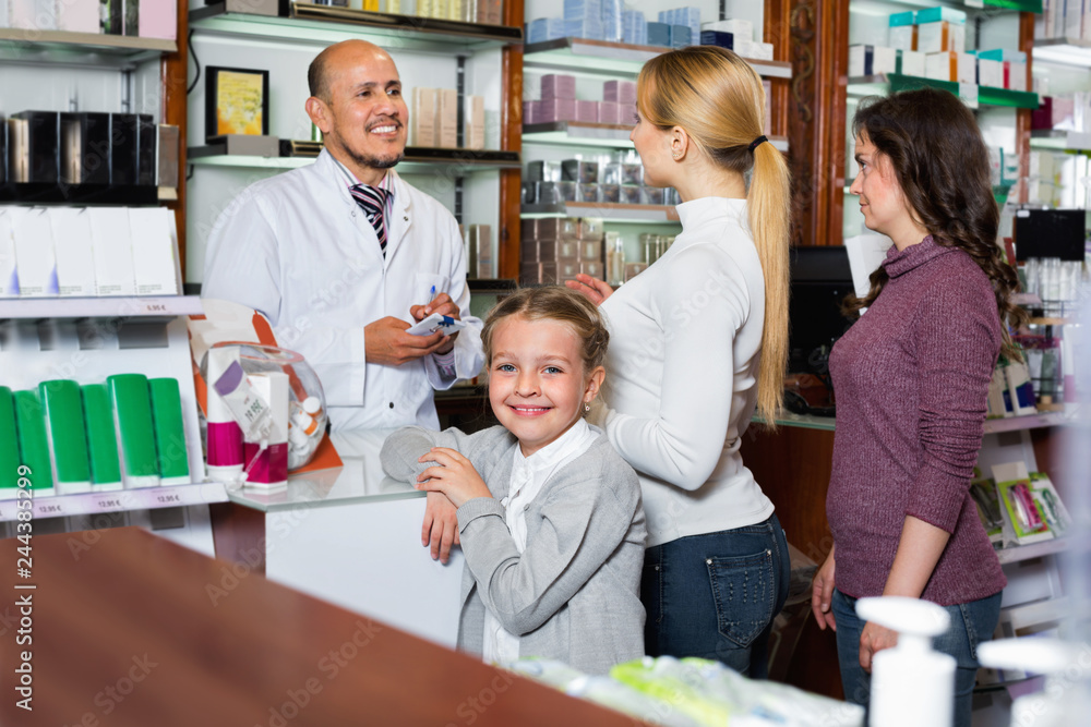 Male pharmacist working pharmaceutical store and consulting customers