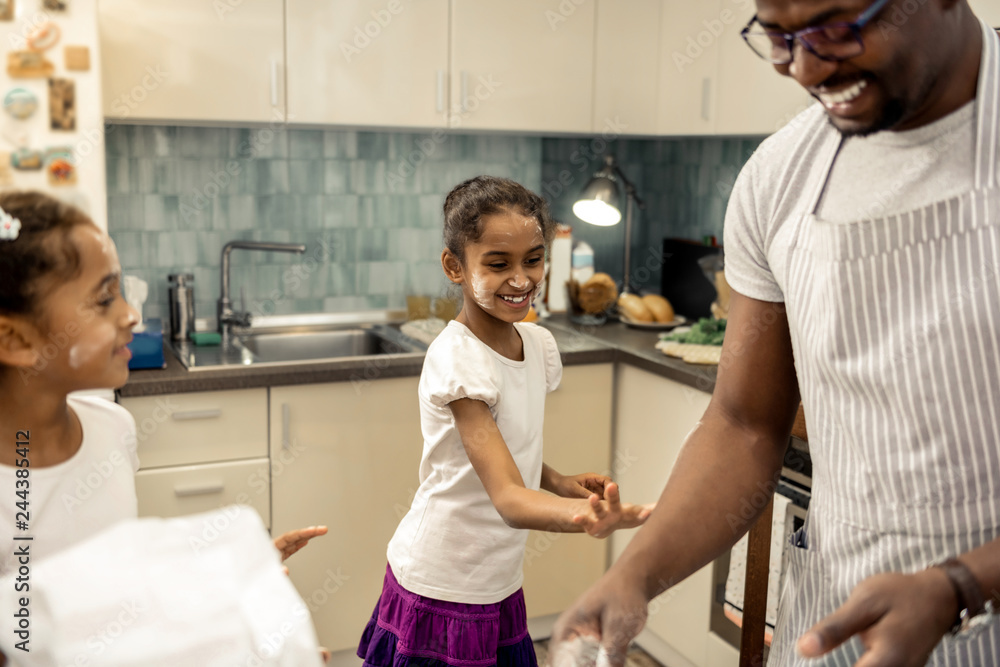 Fototapeta premium Little cute daughter having fun while using flour when cooking