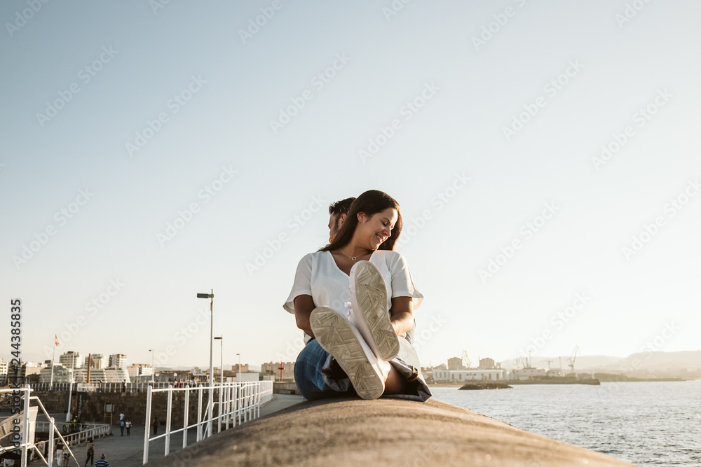 .Young and beautiful couple in love enjoying an afternoon outdoors in Gijón, in Asturias (Spain) overlooking the sea. A fun and playful couple. Love. Lifestyle.