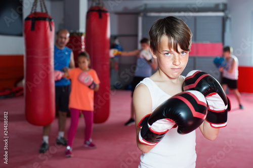 Portrait of young boy with boxing gloves posing