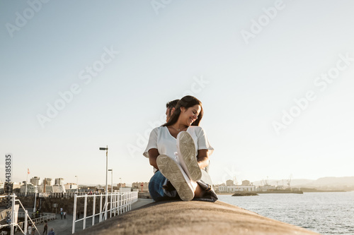 .Young and beautiful couple in love enjoying an afternoon outdoors in Gijón, in Asturias (Spain) overlooking the sea. A fun and playful couple. Love. Lifestyle.