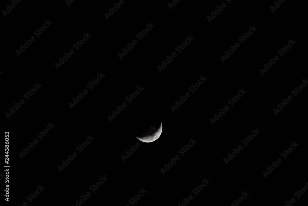 A fantastic moon, only a part of a moon's face is illuminated, the other part remains in the darkness of the night. A fantastic moon, only a part of a moon's face is illuminated, the other part remains in the darkness of the night.