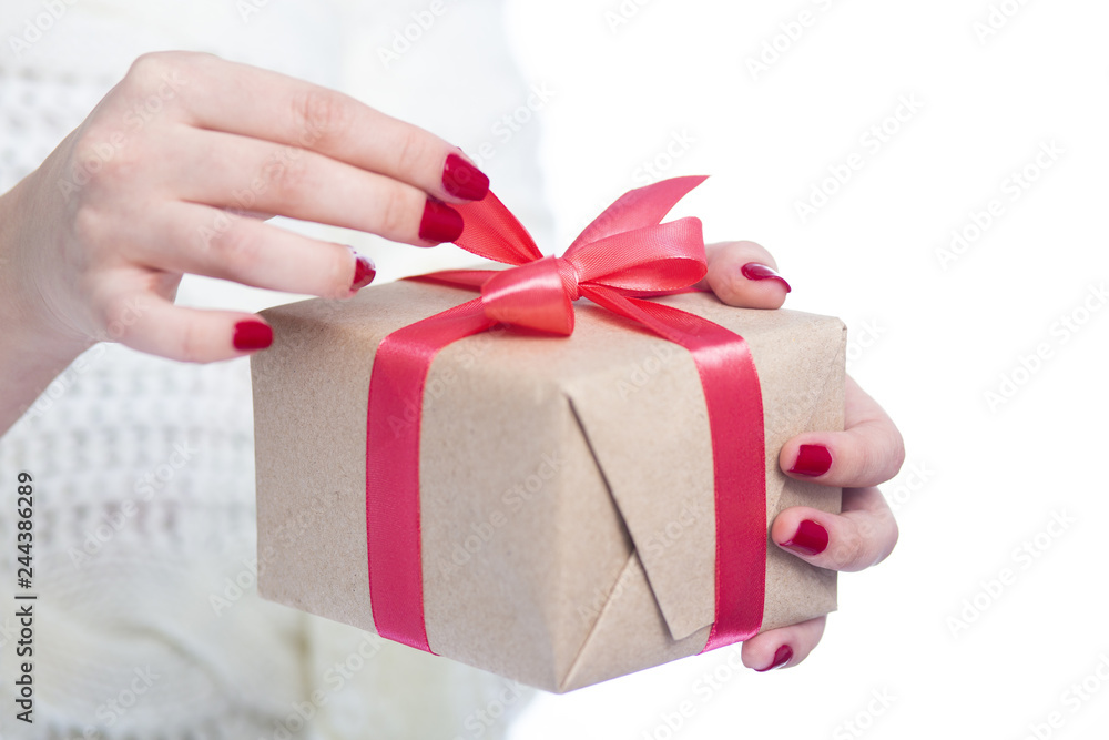 girl holding a present in hands, woman opening the box wrapped in craft paper on white isolated background, concept winter holiday girl holding a present in hands, woman opening the box wrapped in craft paper on white isolated background, concept winter holiday