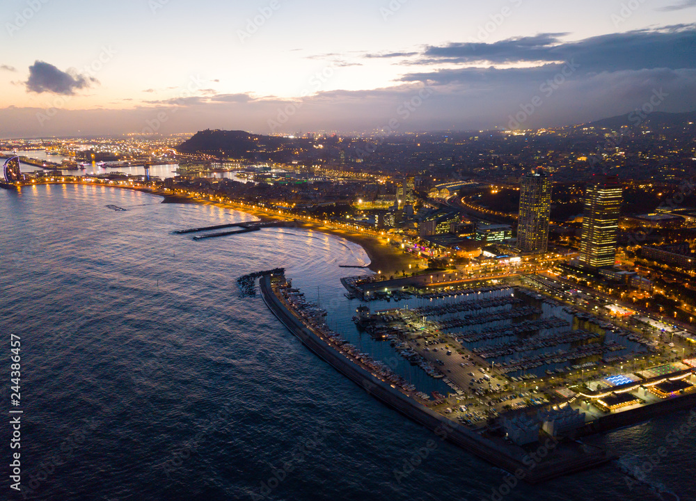 Aerial  view in Barcelona city with coast and  urban part of city at night