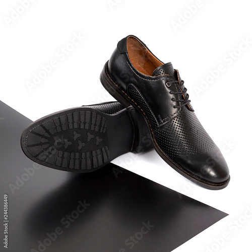 Classic male black leather shoes isolated on a white and black photo