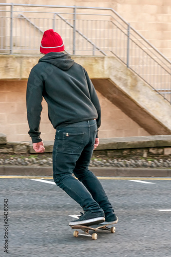 Young boy on the skateboard in a city street