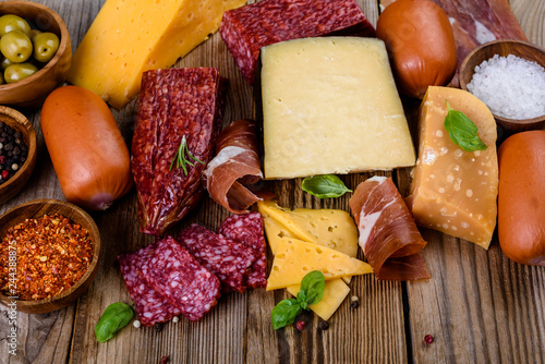 meat plate, prosciutto and cheese, salami, sausage and olives on wooden background