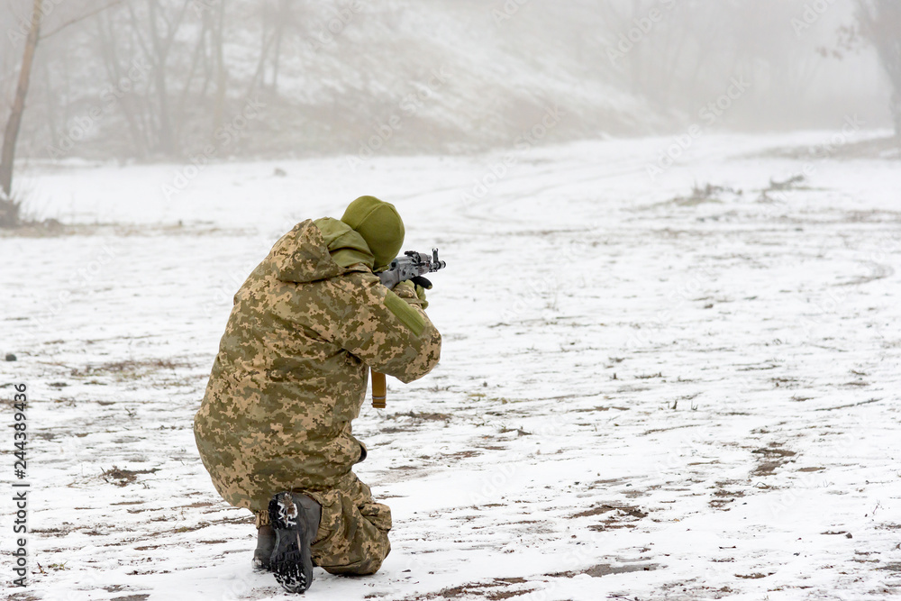 A military soldier in camouflage with a weapon goes on the offensive in winter. A military soldier in camouflage with a weapon goes on the offensive in winter.
