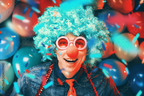 Fototapeta Naklejka Na Ścianę i Meble -  Mann in Karnevalstimmung auf einem Hintergrund aus bunten Lüftballons 