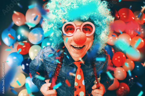 Mann in Karnevalstimmung auf einem Hintergrund aus bunten Lüftballons 
