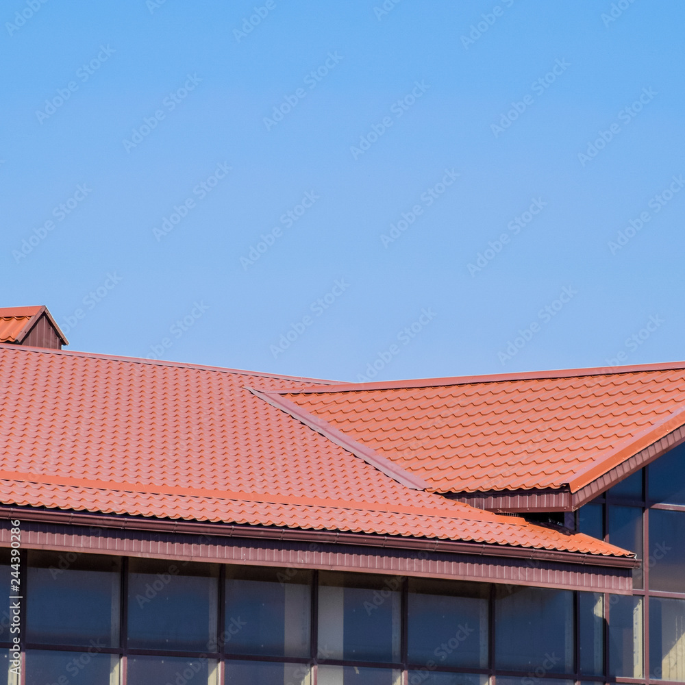 A building with a red-brown roof. Modern materials of finish and A building with a red-brown roof. Modern materials of finish and