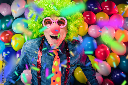 Mann in Karnevalstimmung auf einem Hintergrund aus bunten Lüftballons  © karepa