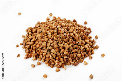 Pile of raw buckwheat seeds on a white background