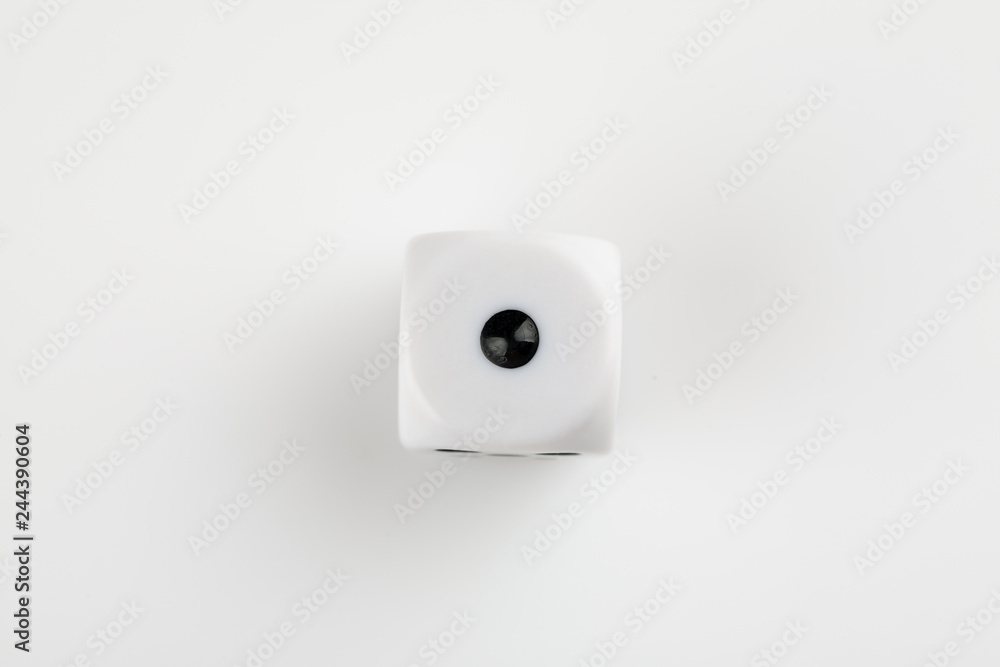 Single white with black dots dice on a white background, showing number one Single white with black dots dice on a white background, showing number one
