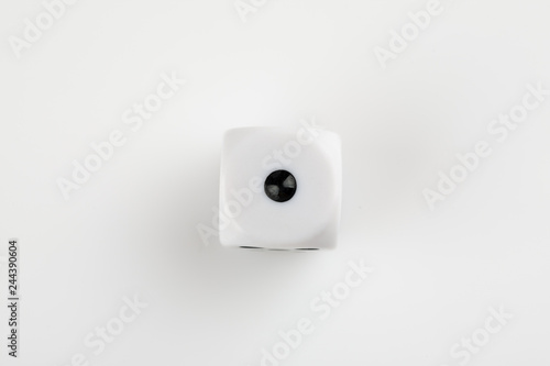Single white with black dots dice on a white background, showing number one