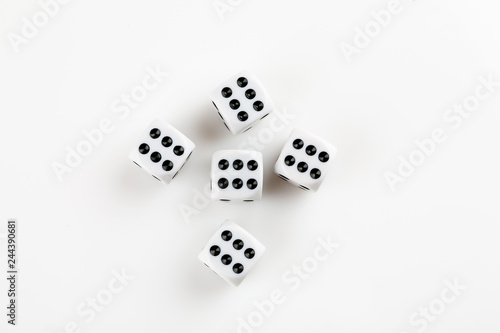 Pile of white with black dots dice with number six on a white background, top view
