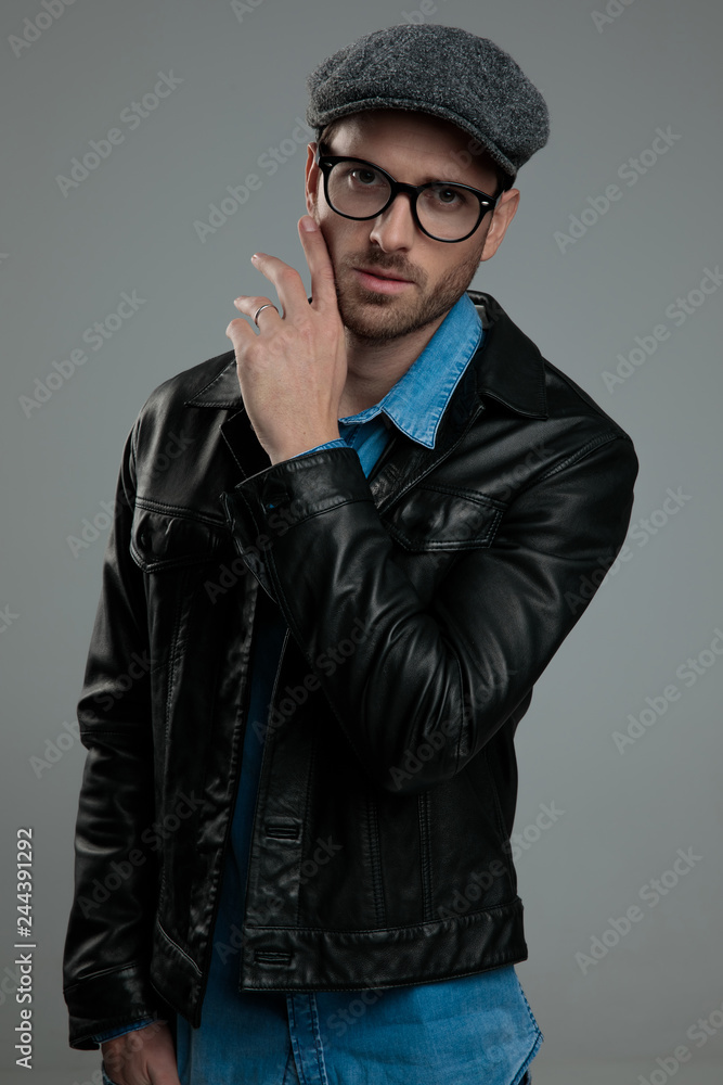 seductive fashion man in leather jacket touching his face seductive fashion man in leather jacket touching his face