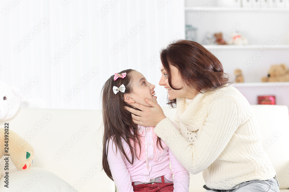 portrait of happy mother and daughter sitting on the couch portrait of happy mother and daughter sitting on the couch