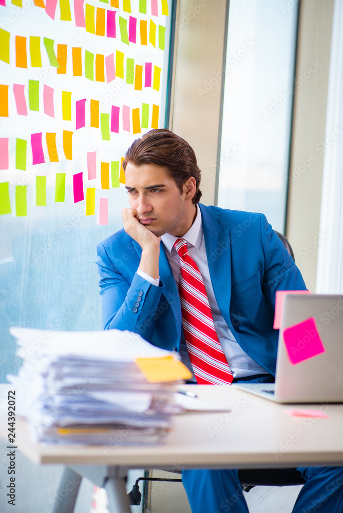 Young handsome employee with many conflicting priorities Young handsome employee with many conflicting priorities