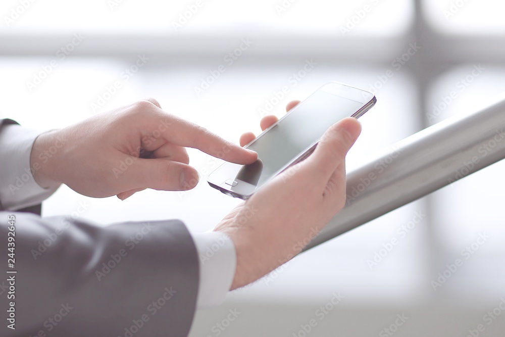 close up. businessman typing SMS on smartphone close up. businessman typing SMS on smartphone