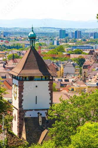 View on the ancient buildings with the Schwabentor clock tower in Freiburg im Breisgau, Germany on a sunny day. photo